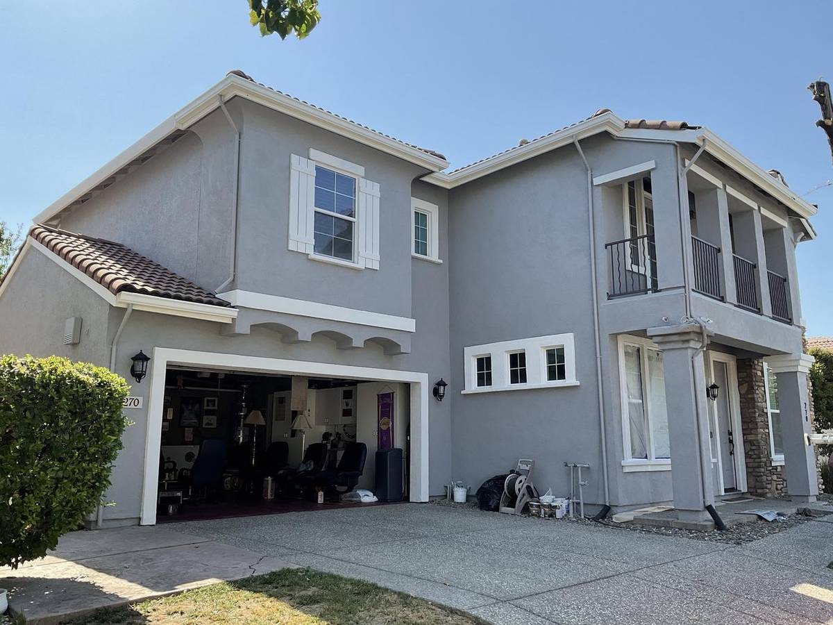 After: the same home in gray with white trim and shutters