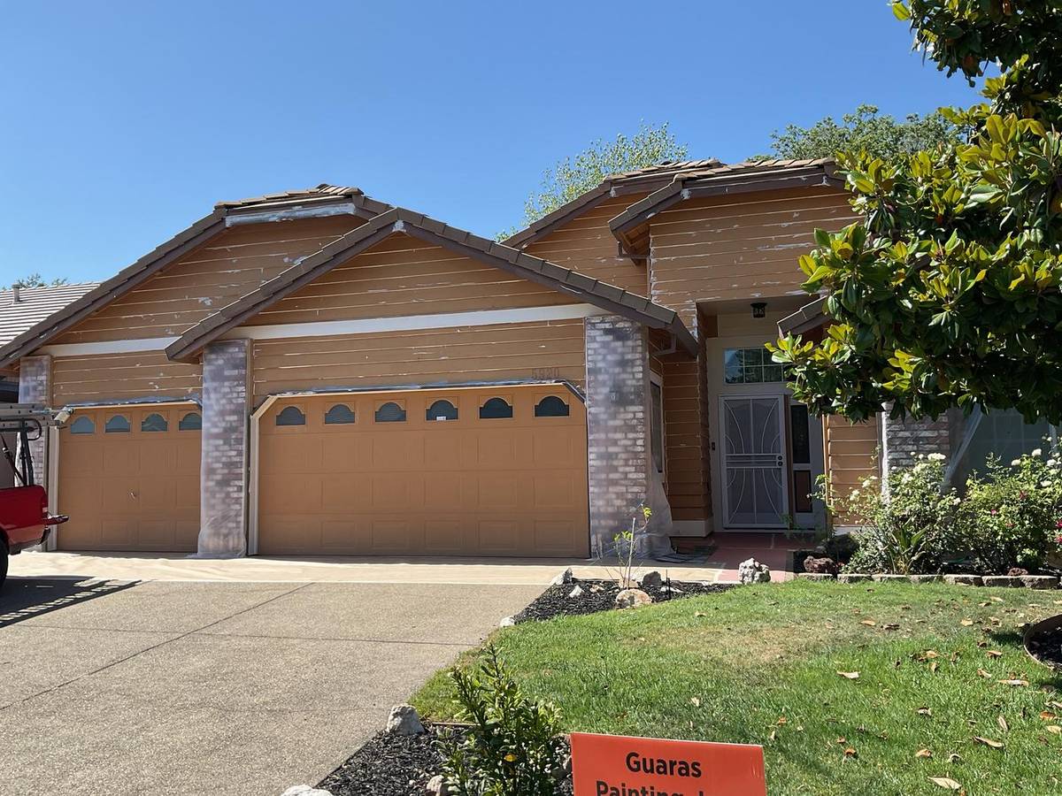 Before: single-story home mid-prep with masked brick and a Guaras Painting yard sign