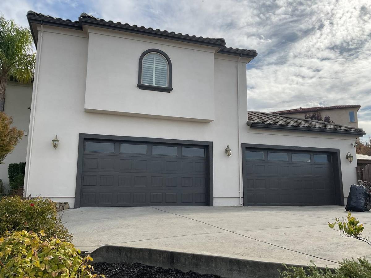 After: the same home painted white with dark trim