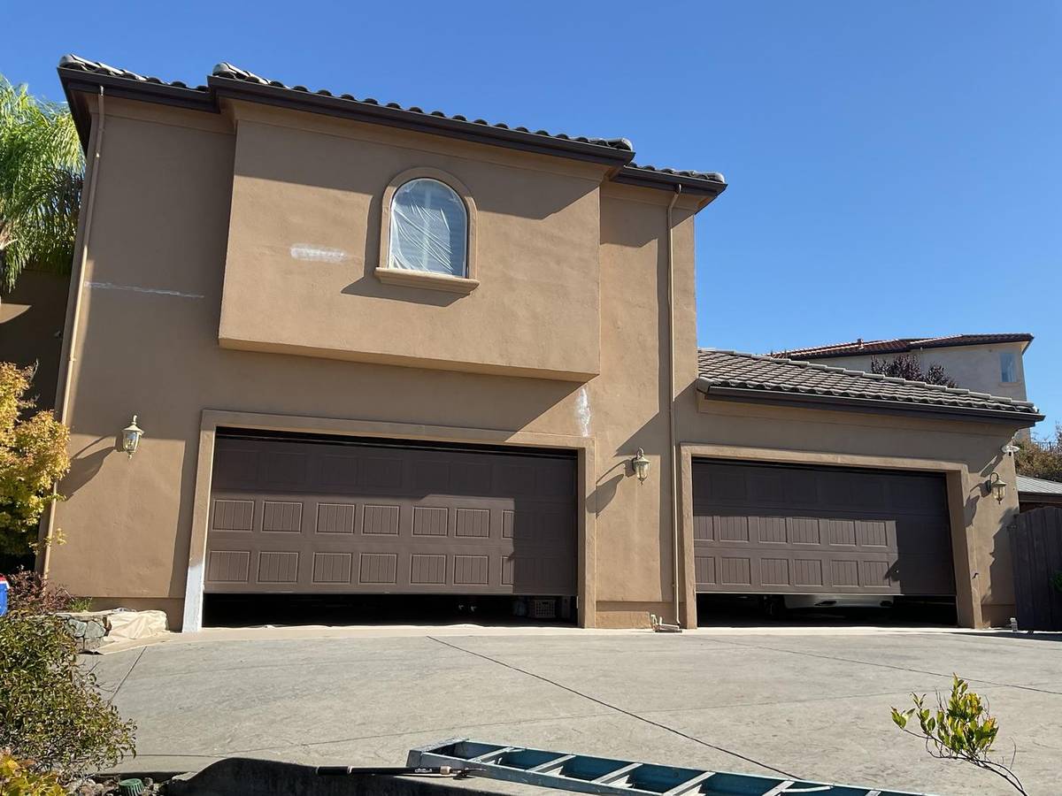 Before: two-story home in tan stucco