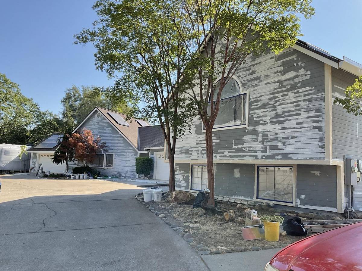 Before: gray lap siding spot-primed during prep